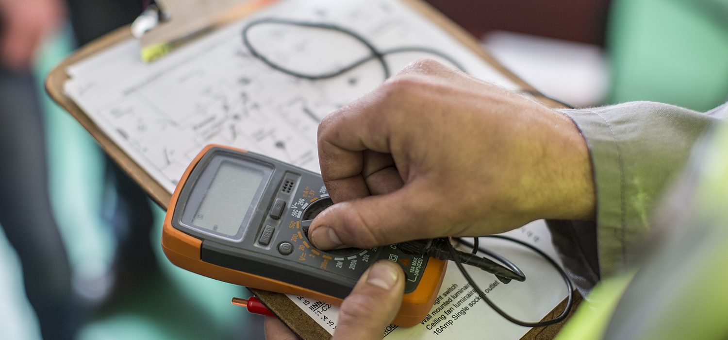 Electrician holding mobile device